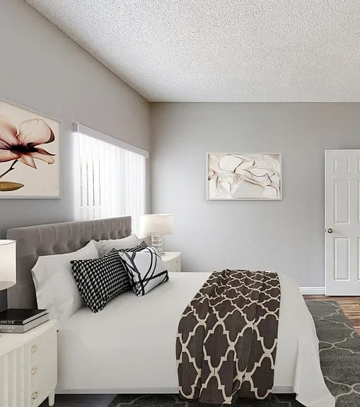 A bedroom with a bed, nightstand, and two framed pictures on the wall.