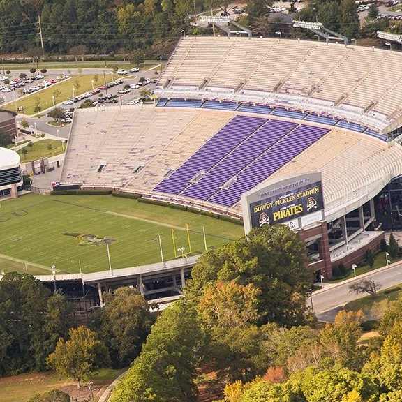 A stadium with a purple field and a yellow sign that says "Pirates".