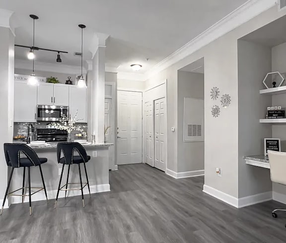 A modern kitchen with a bar area and a home office.