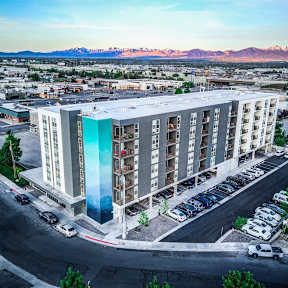 A large building with a blue glass panel in the middle of it.