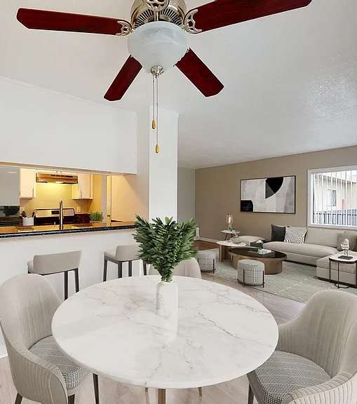 A well-lit, modern kitchen and living room with a dining area.