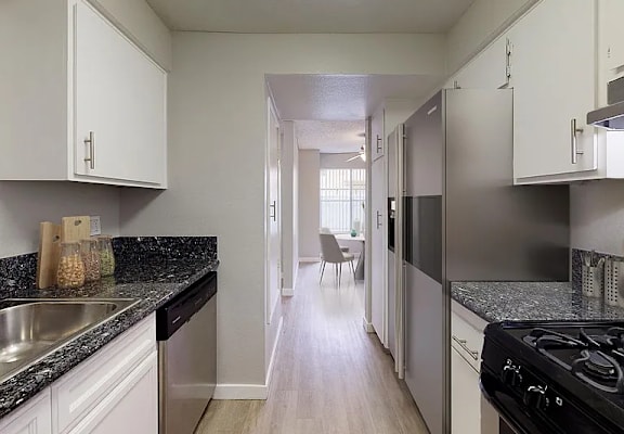 A kitchen with white cabinets and a black stove top oven.
