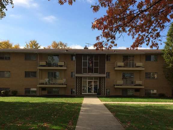a large apartment building with a sidewalk in front of it