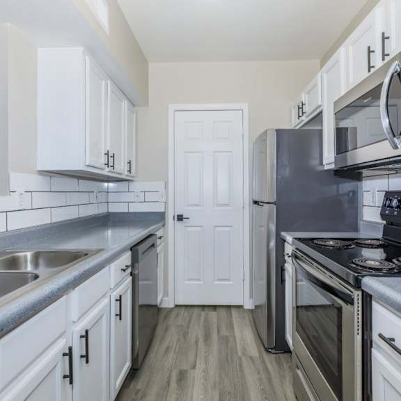A kitchen with white cabinets and a white island.