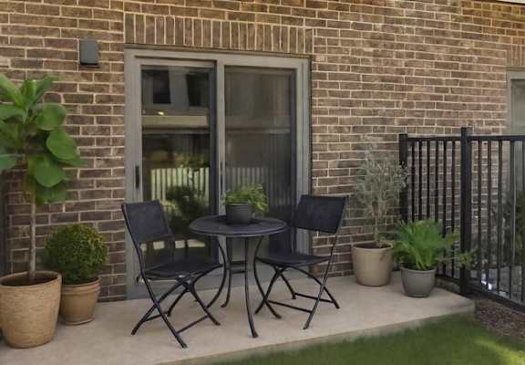 A patio with a table and chairs is set up outside a brick building.