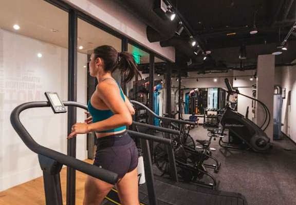 Woman running on a treadmill in a gym at Fedora x Trilby in Los Angeles, CA 90005