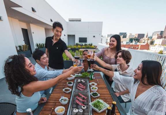 Group of people sitting around a table eating and drinking wine at Fedora x Trilby in Los Angeles, CA 90005