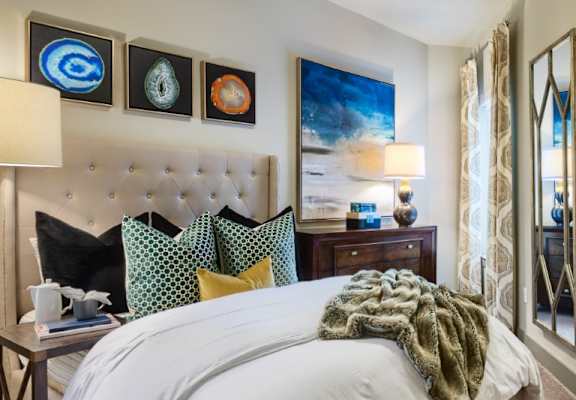 A bedroom with a large bed and a painting on the wall.