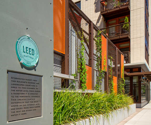 A sign on a building reads LEED and has a plaque below it.