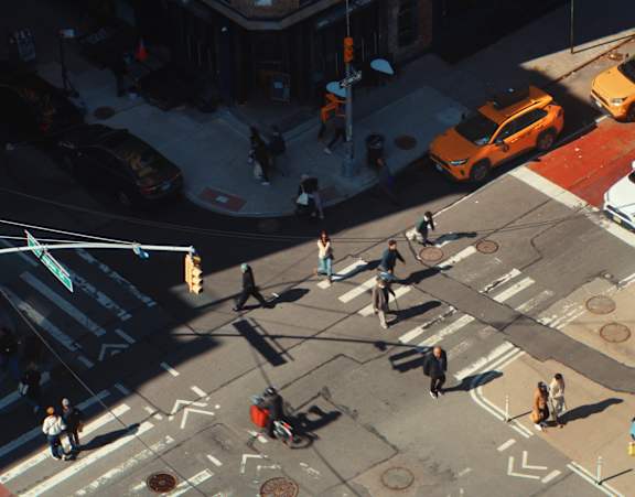 A busy city intersection with cars and pedestrians.