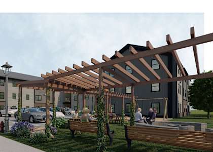 A modern building with a wooden pergola and people sitting on benches.