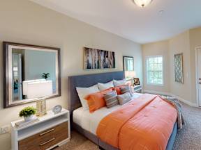 A bedroom with a large bed and a painting on the wall.