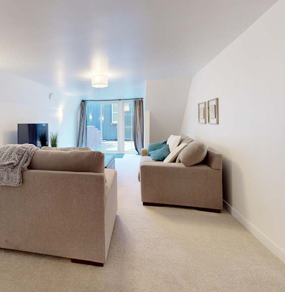 Two beige couches in a room with a door in the background.