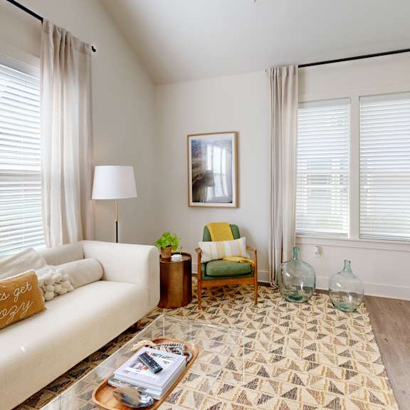 an open concept living room and dining area with a white dining table and rattan chairs