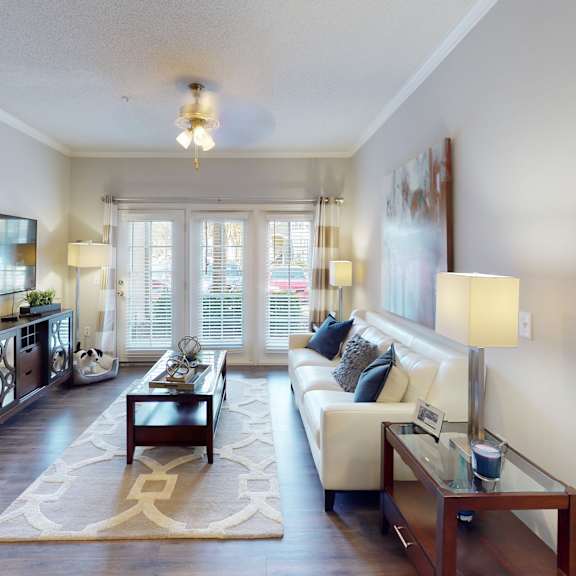 an open concept living room and dining area with a white dining table and rattan chairs
