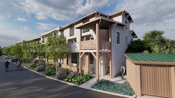 A modern apartment complex with a green roof and a bicycle parked outside one of the units.