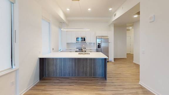 a kitchen with white walls and a wooden floor, Opens in new tab