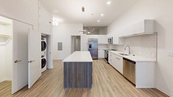 a kitchen with white walls and a wooden floor, Opens in new tab