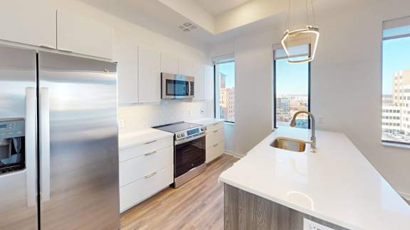 a kitchen with white walls and a wooden floor, Opens in new tab