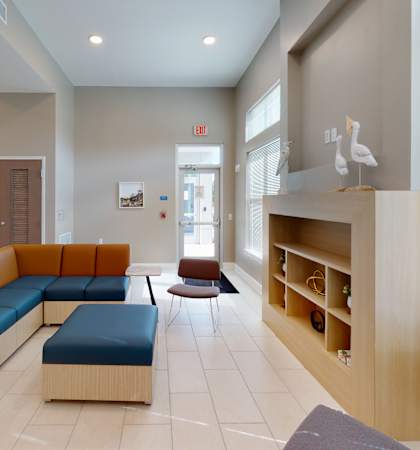a waiting room at a hospital with couches and a desk