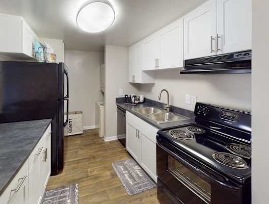 a kitchen with white cabinets and black appliances