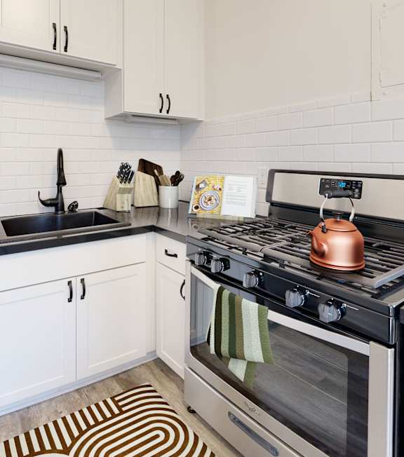 A modern kitchen with a stove top oven and a refrigerator.