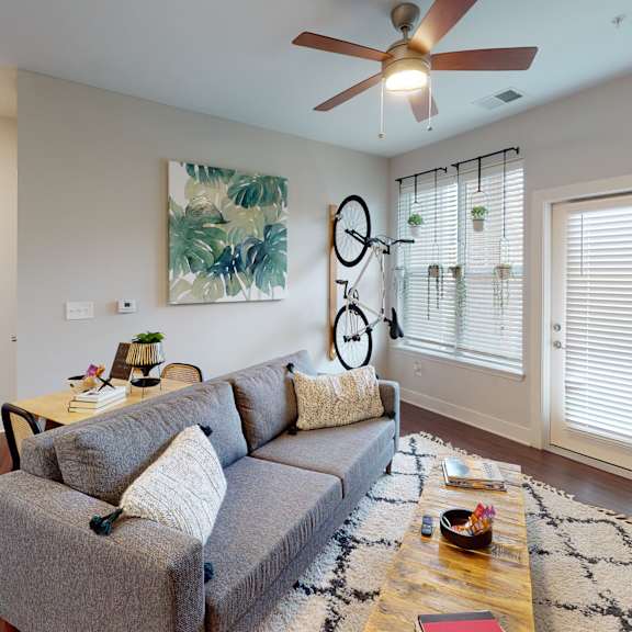an open concept living room and dining area with a white dining table and rattan chairs