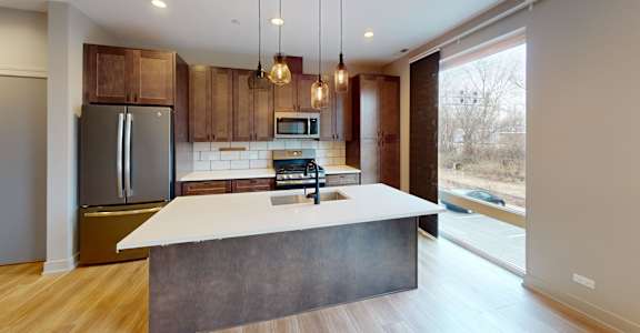 A modern kitchen with a large island and wooden cabinets.