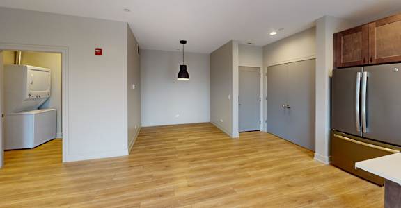 A kitchen with a refrigerator, sink, and cabinets.