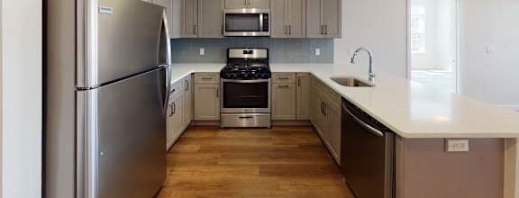 a kitchen with stainless steel appliances and white counter tops