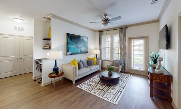 a living room with hardwood floors and a ceiling fan