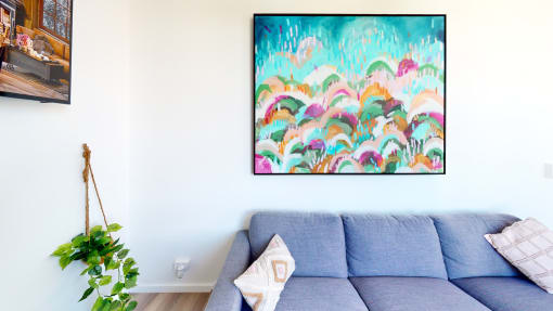 a living room with a couch and a painting on the wall