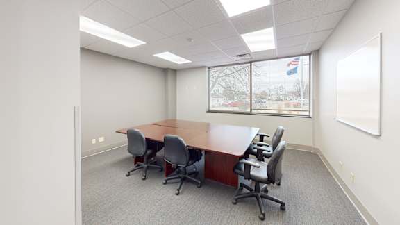 A conference room with a long table and chairs.