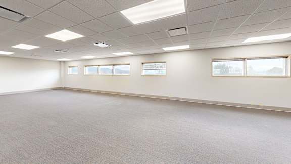 Empty room with carpeted floor and ceiling lights.