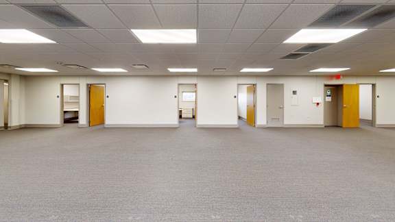 A large empty room with doors on both sides.