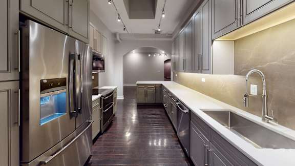 A modern kitchen with stainless steel appliances and a marble backsplash.