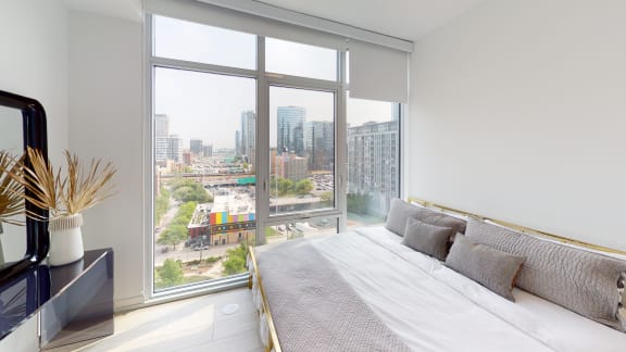 a bedroom with a bed and a large window