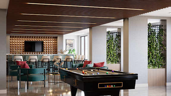 A pool table is in the middle of a room with a tv and chairs. at Refinery at Pointe17 Apartments, Phoenix, AZ, 85085