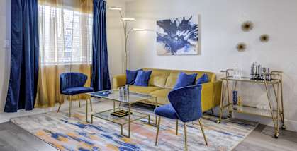 a living room with a yellow couch and blue chairs