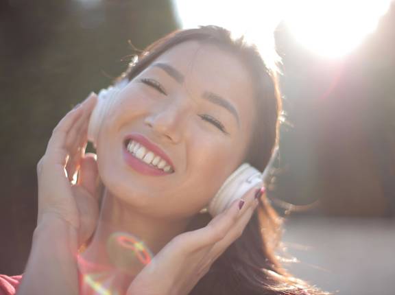 A woman is enjoying music with headphones on.