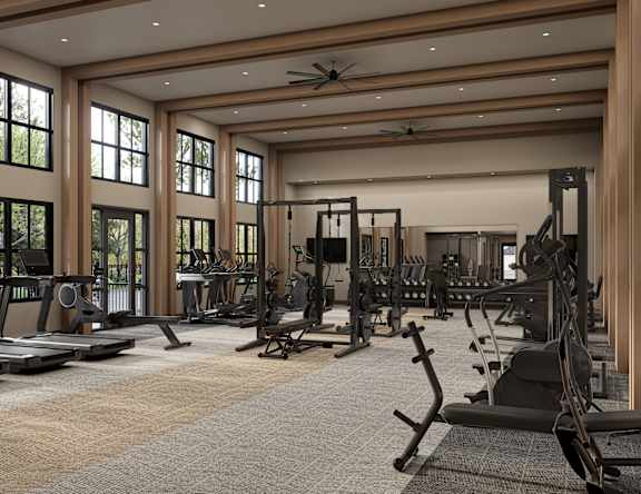 A spacious gym with a variety of equipment and large windows.