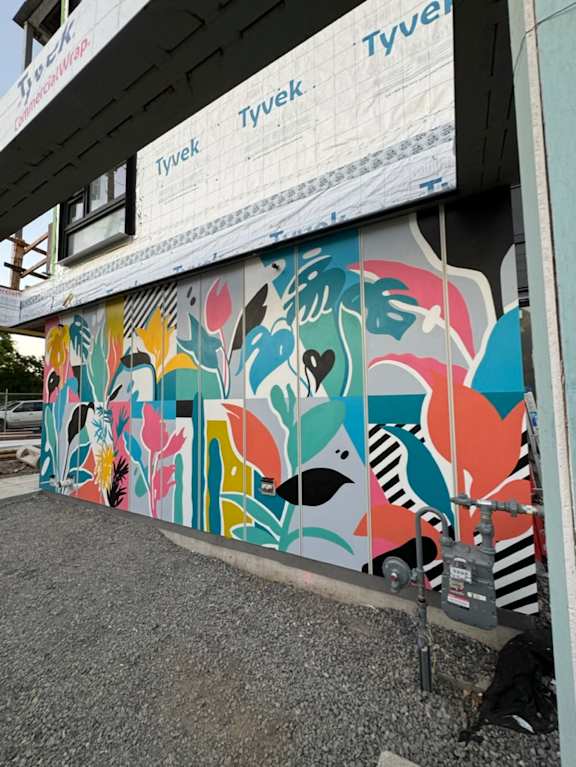 A mural of a face with a black hat and a black and white striped shirt.