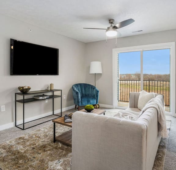 a living room with a couch and a television  at Signature Pointe Apartment Homes, Athens, 35611
