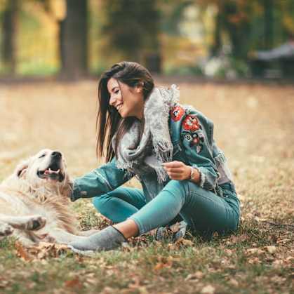 A woman is sitting on the ground with her dog at Amberleigh, Virginia