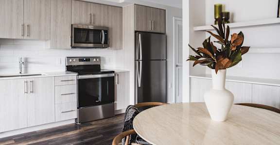 A modern kitchen with a wooden table and chairs.