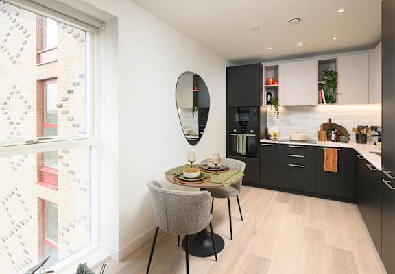 A modern kitchen with a dining table and chairs.