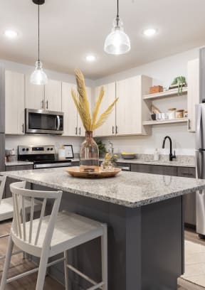 apartment kitchen with stainless steel appliances and granite countertops at Lake Nona Concorde