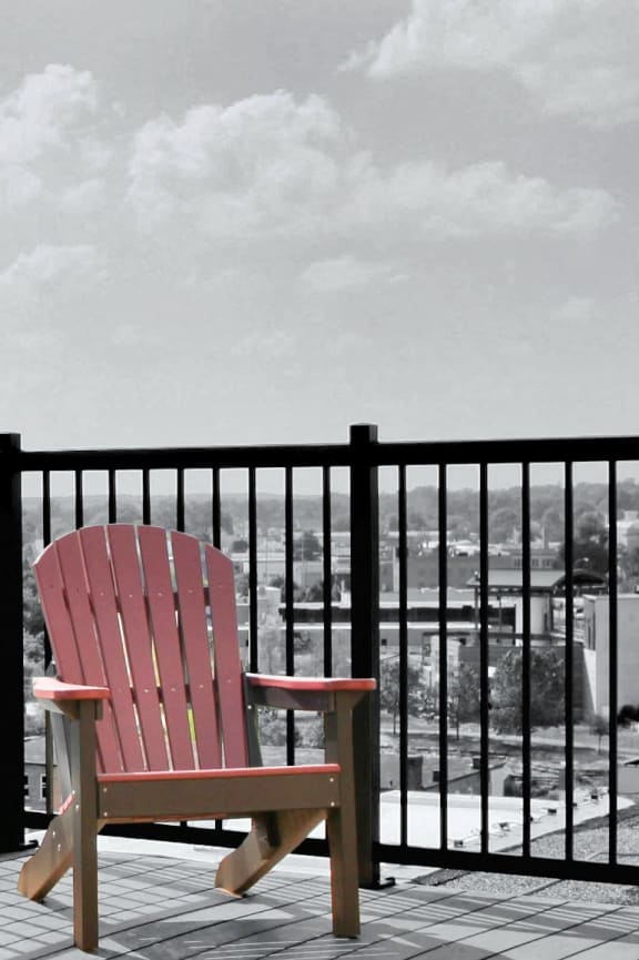 a patio with tables and chairs on a balcony with a grill