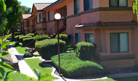 a row of houses with balconies and manicured lawns