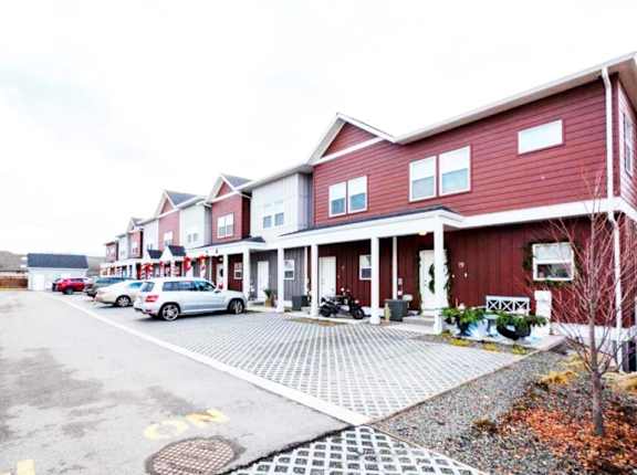 A red building with a white car parked in front.